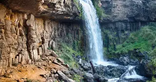 Waterfall cascading down rocky cliff