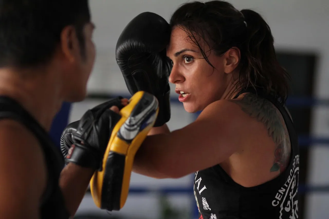 Woman wearing boxing gloves punching another person