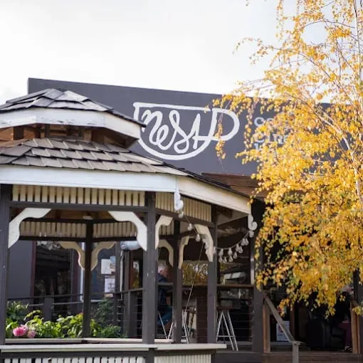 Building with covered porch and yellow tree
